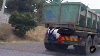 African Kid Hanging On Dump Truck GIF