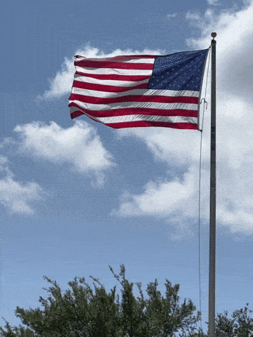 American Flag Flying in Cloudy Blue Sky