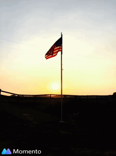 American Flag Silhouetted Against Sunset With Momento Logo