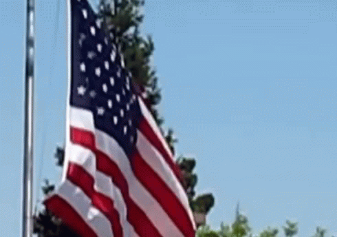 American Flag Waving Against Blue Sky