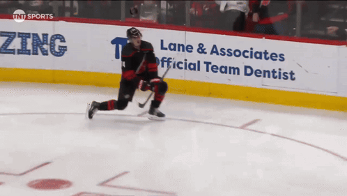 An Advertisement For Lane & Associates Official Team Dentist Is On The Side Of A Hockey Rink GIF