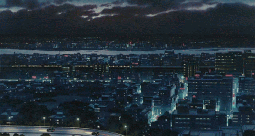 An Aerial View Of A City At Night With Cars On The Road GIF