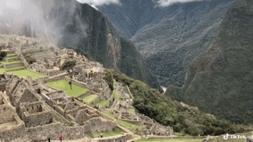 An Aerial View Of A City In The Middle Of A Mountain Range GIF