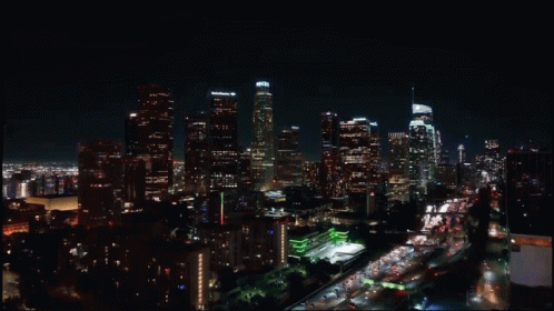 An Aerial View Of A City Skyline At Night With A Few Buildings Lit Up Including One That Says Chase GIF