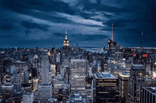 An Aerial View Of A City With A H & M Sign On The Top Of A Building GIF