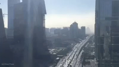 An Aerial View Of A City With A Highway And A Lot Of Traffic . GIF