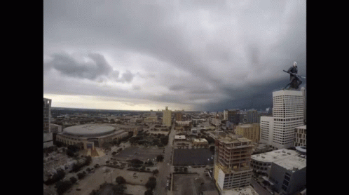 An Aerial View Of A City With A Person On Top Of A Tall Building GIF