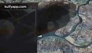 An Aerial View Of A City With A River Running Through It And A Large Hole In The Ground . GIF