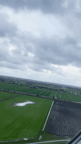 An Aerial View Of A Field With A Cloudy Sky In The Background GIF