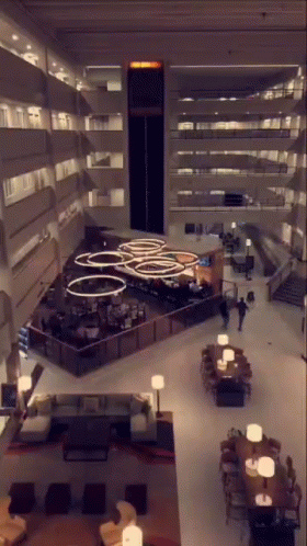 An Aerial View Of A Hotel Lobby With Tables Chairs And Lamps GIF