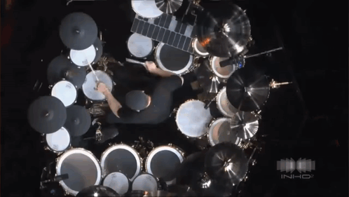 An Aerial View Of A Man Playing Drums In A Dark Room With The Word Inhd In The Corner GIF