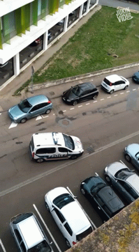 An Aerial View Of A Parking Lot With A Police Car In The Foreground GIF