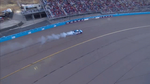 An Aerial View Of A Race Track With A Car That Has Smoke Coming Out Of Its Tires GIF
