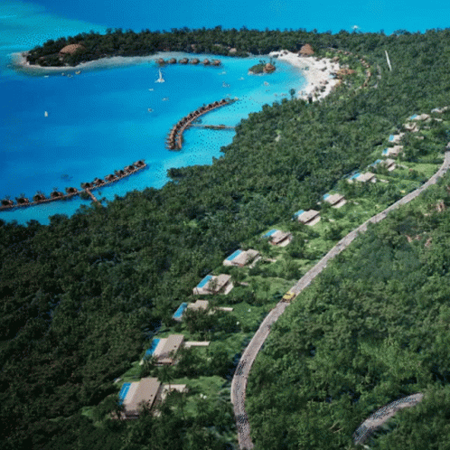An Aerial View Of A Tropical Island With A Few Houses On It GIF