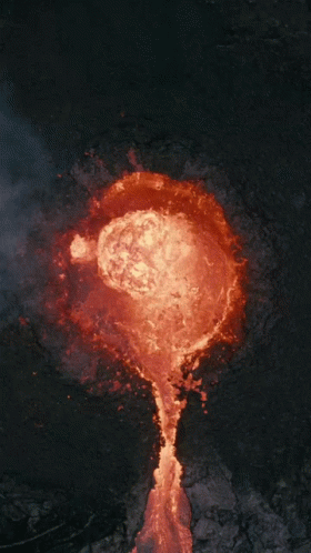 An Aerial View Of A Volcano With Lava Coming Out Of The Crater GIF
