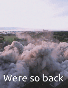 An Aerial View Of Smoke Coming Out Of A Building With The Words Were So Back Below It GIF