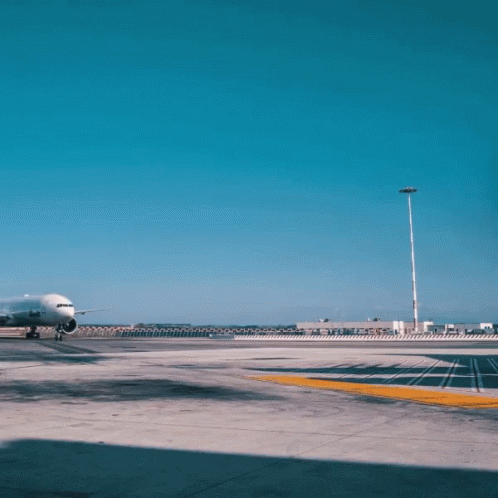 An Airplane Is Parked On A Runway With A Building In The Background That Says Airways GIF