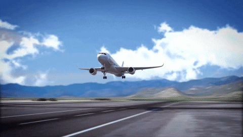 an airplane taking off from an airport runway with mountains in the background