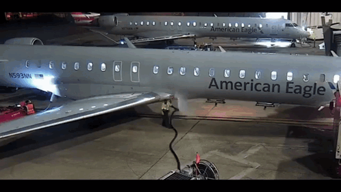 An American Eagle Airplane Is Parked In A Hanger GIF