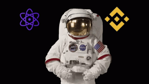 An Astronaut Is Holding A Purple Atom And A Yellow Symbol In His Hands GIF