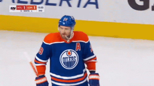 An Edmonton Oilers Hockey Player Is Standing On The Ice GIF