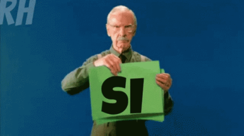 an elderly man holds a green sign that says si si