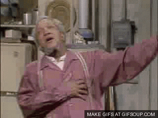 An Elderly Man In A Pink Jacket Is Standing In Front Of A Refrigerator With His Arms Outstretched . GIF