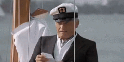 An Elderly Man In A Suit And Hat Is Holding A Piece Of Paper In His Hand . GIF