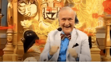 an elderly man in a suit and tie is sitting on a throne with a microphone on his head .