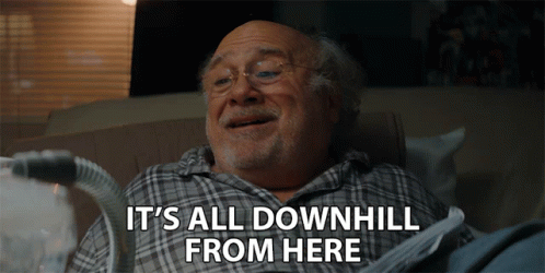 An Elderly Man Is Laying On A Couch With The Words " It 'S All Downhill From Here " Above Him GIF