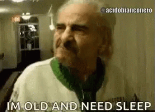 An Elderly Man Is Standing In A Room And Says `` I 'M Old And Need Sleep '' . GIF