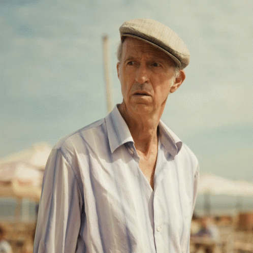 An Elderly Man Wearing A Hat And A Striped Shirt GIF