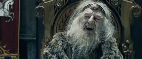 An Elderly Man With A Beard Is Sitting On A Throne And Smiling . GIF