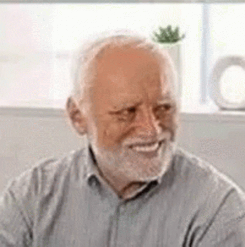 An Elderly Man With A Beard Is Smiling And Looking At The Camera . GIF
