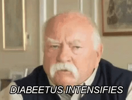 An Elderly Man With A Mustache Is Sitting In A Living Room . GIF
