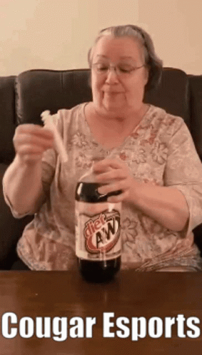 An Elderly Woman Is Holding A Toothbrush And A Bottle Of Root Beer .. GIF