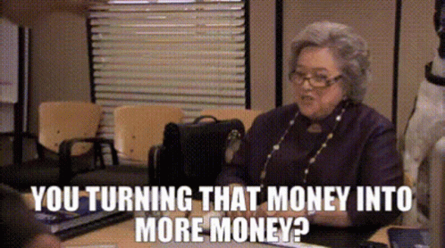 An Elderly Woman Is Sitting At A Desk Talking To Someone And The Words You Turning That Money Into More Money GIF