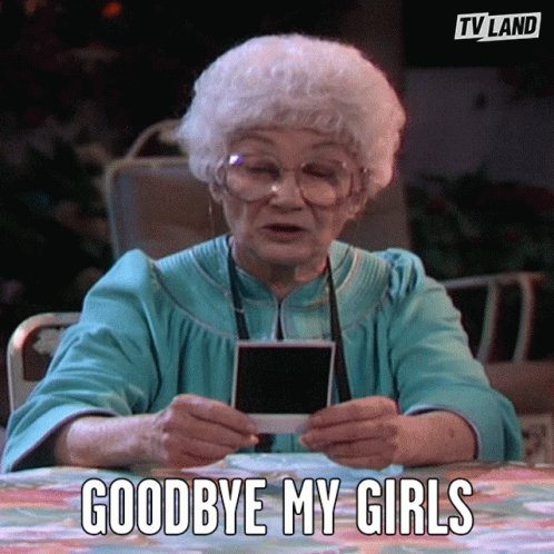 An Elderly Woman Is Sitting At A Table Holding A Photo And Saying Goodbye My Girls GIF