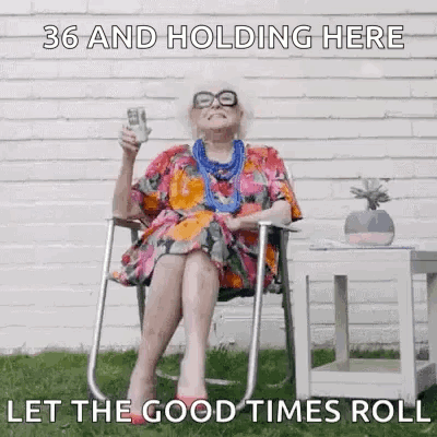 An Elderly Woman Is Sitting In A Chair Holding A Bottle Of Wine And A Dollar Bill . GIF
