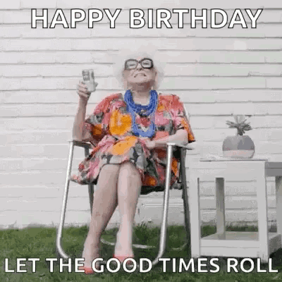 An Elderly Woman Is Sitting In A Chair Holding A Glass Of Beer And A Birthday Card . GIF