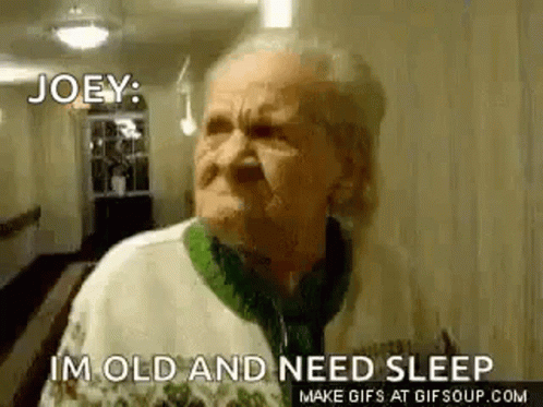 An Elderly Woman Is Standing In A Hallway And Making A Funny Face . GIF