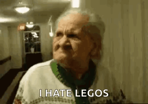 An Elderly Woman Is Standing In A Hallway With A Serious Look On Her Face And Says `` I Hate Legos '' . GIF