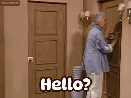 an elderly woman is standing in front of a door and says hello