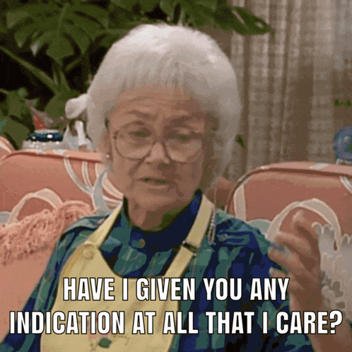 An Elderly Woman Sitting On A Couch Asking If She Has Any Indication At All That She Cares GIF