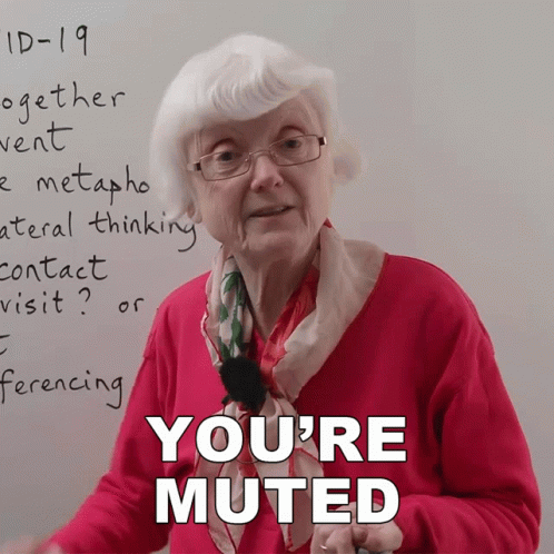 an elderly woman stands in front of a whiteboard with the words " you 're muted " on it