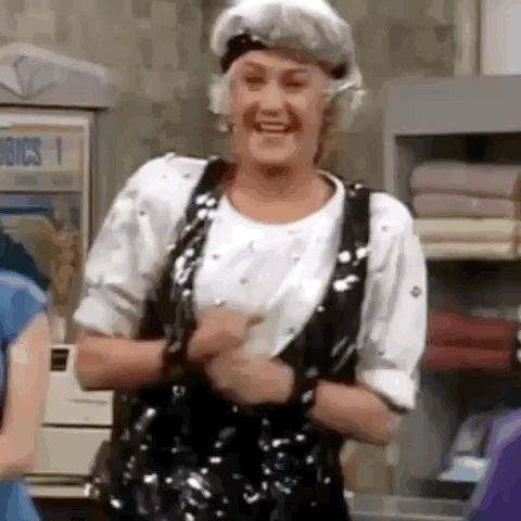 An Elderly Woman Wearing A Shower Cap Is Dancing In A Room . GIF