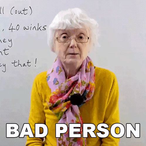 An Elderly Woman Wearing Glasses And A Scarf Says Bad Person In Front Of A Whiteboard GIF