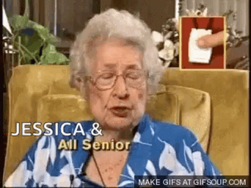 An Elderly Woman Wearing Glasses Is Sitting In A Chair And Talking To Someone . GIF