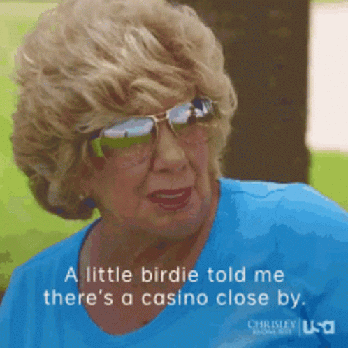 An Elderly Woman Wearing Sunglasses And A Blue Shirt Says A Little Birdie Told Me There 'S A Casino Close By GIF