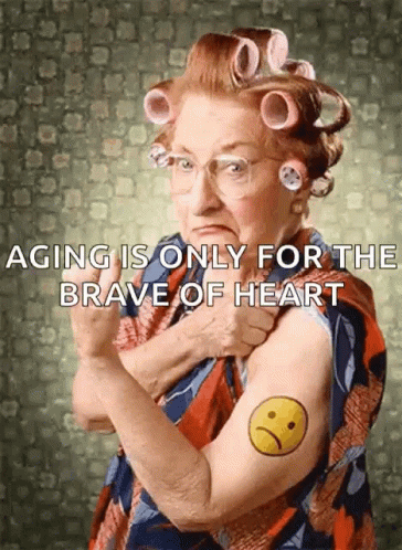 An Elderly Woman With Curlers On Her Hair Has A Tattoo Of An Angry Face On Her Arm GIF